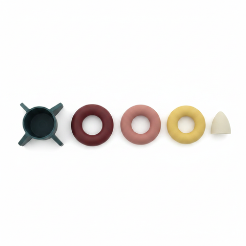 Silicone rocket stacking toy rings disassembled flat lay white background